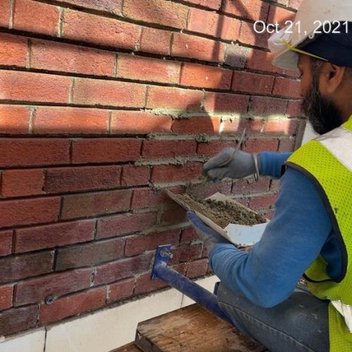 Skilled construction workers building brick wall in New York